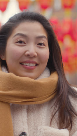 Vertical-Video-Portrait-Of-Smiling-Young-Asian-Woman-Visiting-Chinatown-In-London-UK